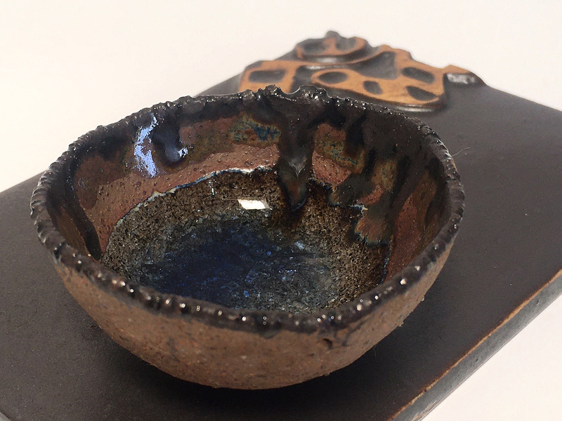 Salero sobre base de cerámica con relieve - Figura étnica oscura + vidrio